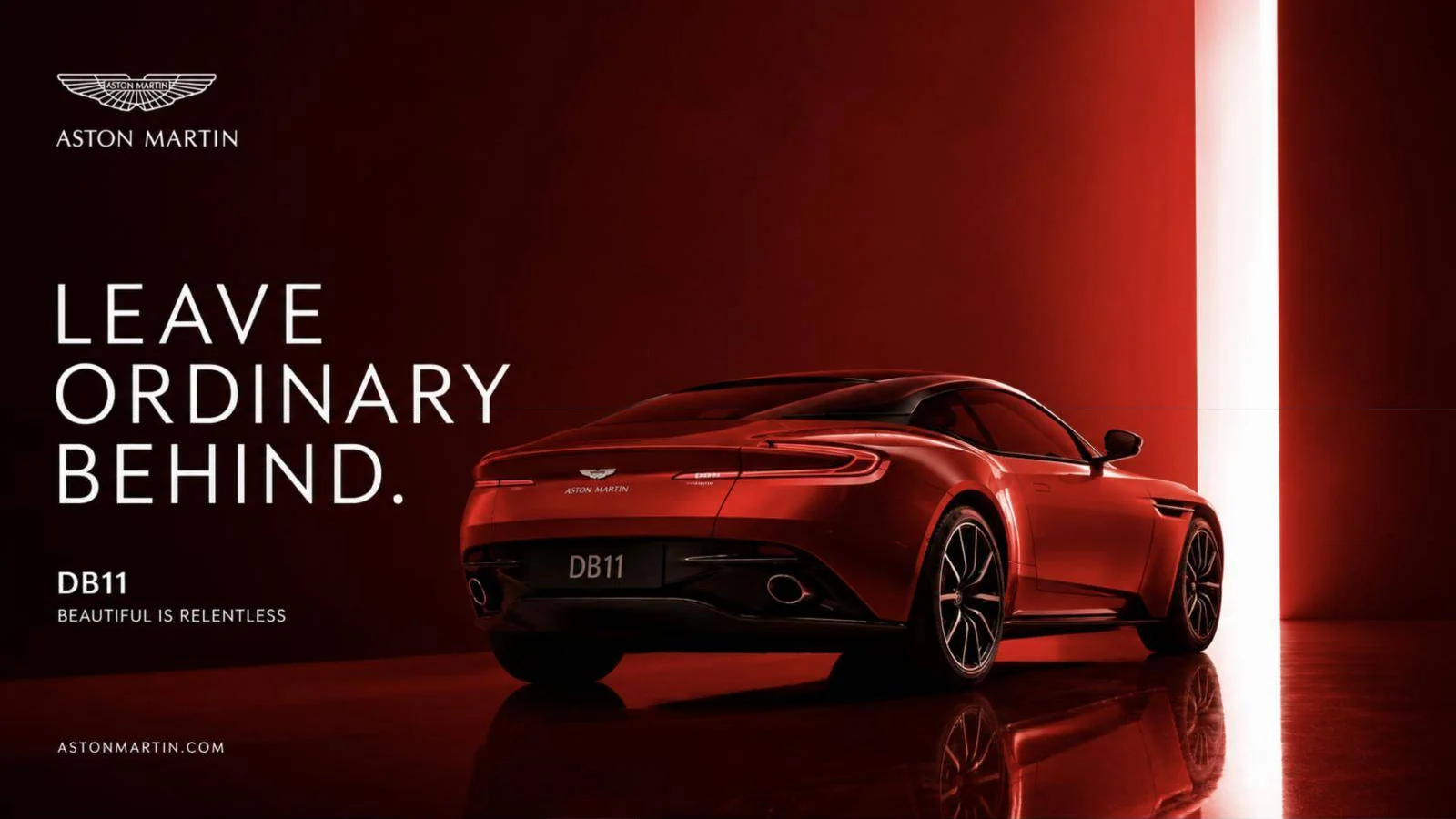 Aston Martin DB11 key visual: a red DB11 in a dark red studio with the line ‘Leave ordinary behind’